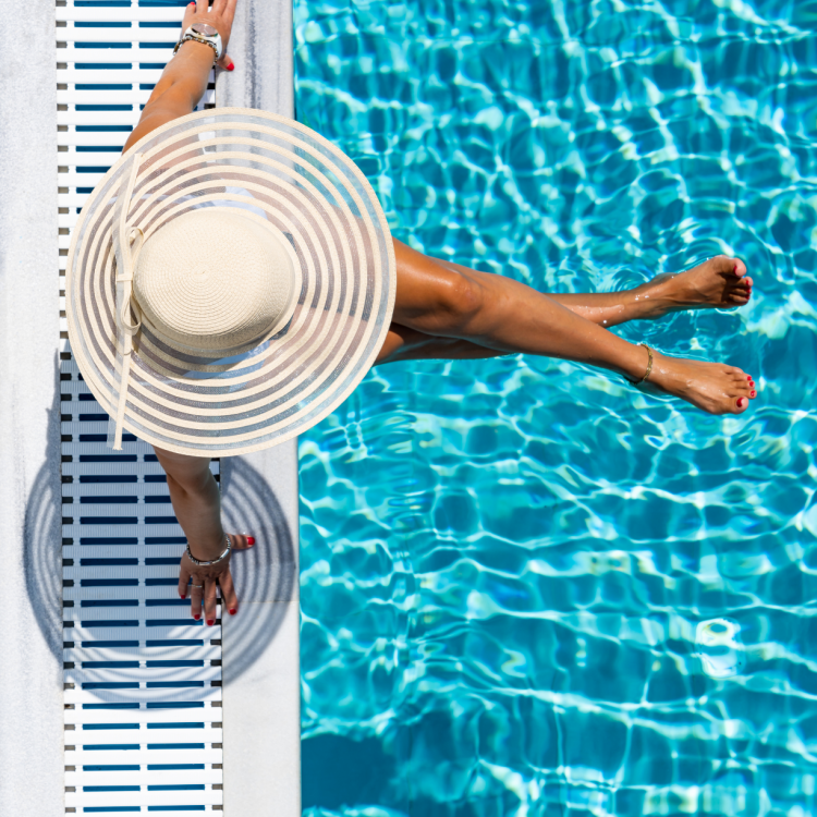 Woman with legs dangling over edge of pool